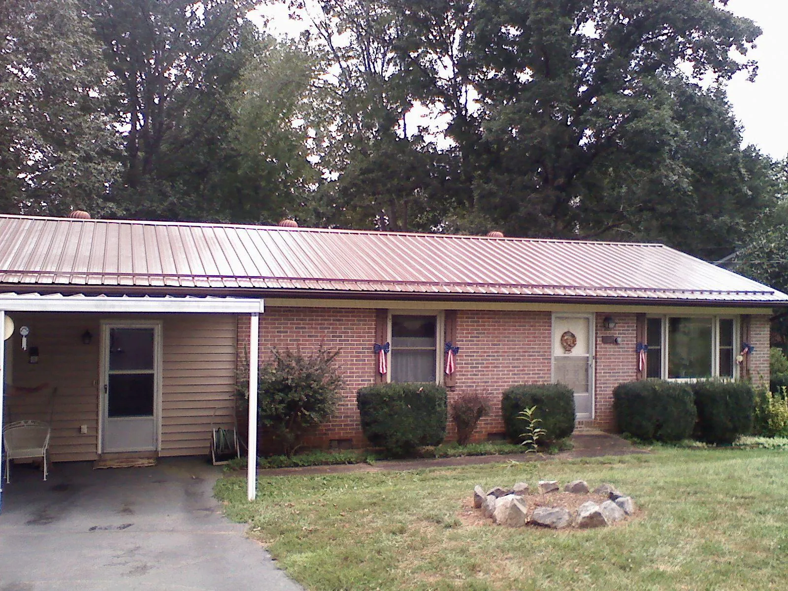 Bronze metal roof and carport on a brick ranch home — Roof Repair work by our crew in Edgewood